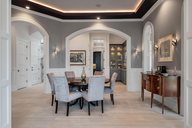 79 Trailing Vine Way, Kiawah Island, SC 29455 - dining room with a decorative wall, wainscoting, a raised ceiling, light wood-type flooring, and crown molding