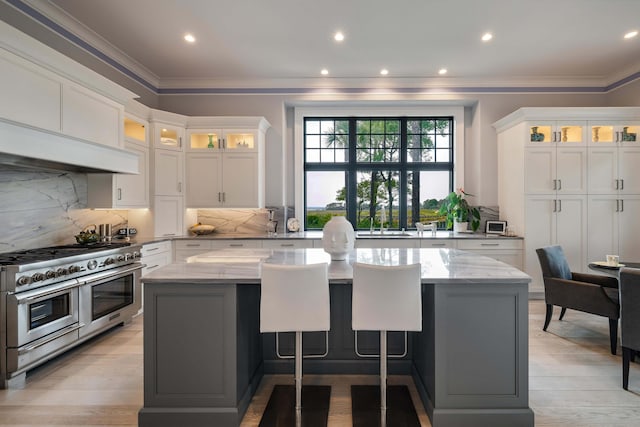 79 Trailing Vine Way, Kiawah Island, SC 29455 - kitchen featuring double oven range, a kitchen island, ornamental molding, light stone countertops, and tasteful backsplash
