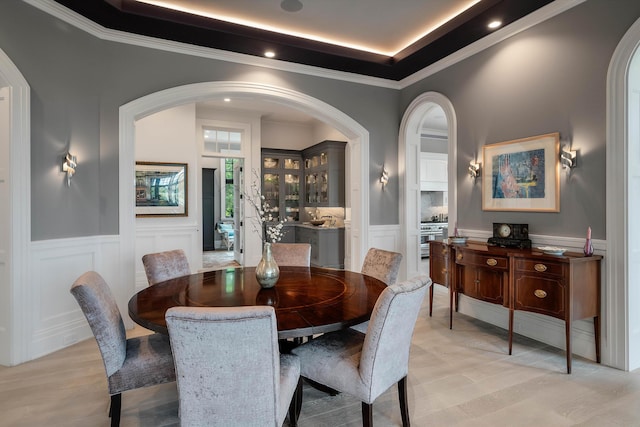 79 Trailing Vine Way, Kiawah Island, SC 29455 - dining room with a decorative wall, a raised ceiling, a wainscoted wall, crown molding, and arched walkways