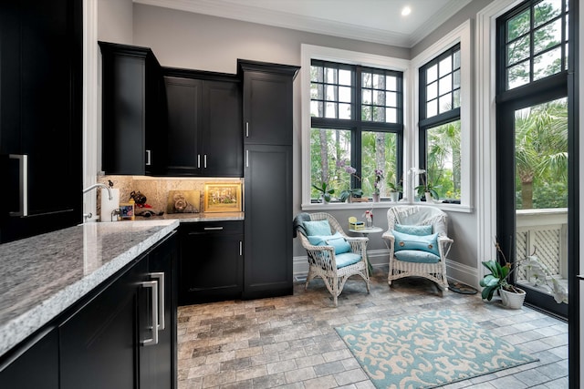 79 Trailing Vine Way, Kiawah Island, SC 29455 - kitchen with dark cabinetry, crown molding, light stone counters, decorative backsplash, and recessed lighting