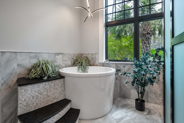 79 Trailing Vine Way, Kiawah Island, SC 29455 - full bath featuring tile walls, a freestanding tub, healthy amount of natural light, a wainscoted wall, and tile patterned floors