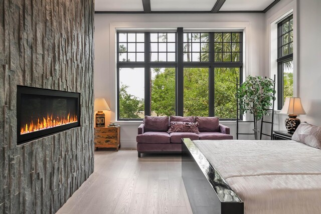 79 Trailing Vine Way, Kiawah Island, SC 29455 - bedroom with wood finished floors, multiple windows, and a glass covered fireplace