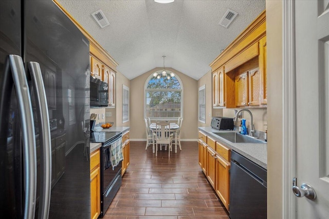 kitchen with a chandelier, vaulted ceiling, black appliances, a sink, and visible vents