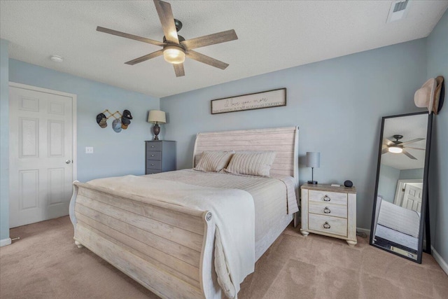 bedroom with light colored carpet, ceiling fan, visible vents, and baseboards
