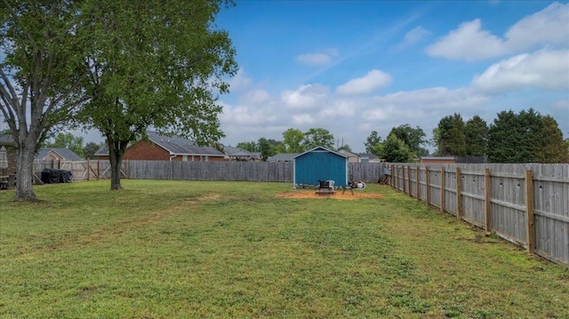 view of yard with an outdoor structure, a fenced backyard, and a storage shed