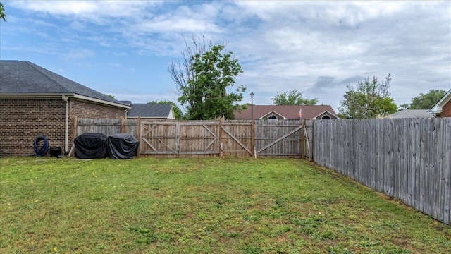 view of yard with a gate and a fenced backyard