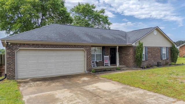 ranch-style home featuring driveway, roof with shingles, a front yard, an attached garage, and brick siding