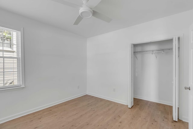 unfurnished bedroom with ceiling fan, light wood-type flooring, and a closet