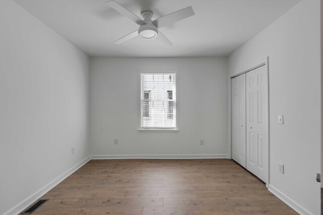 unfurnished bedroom featuring a closet, ceiling fan, and light wood-type flooring