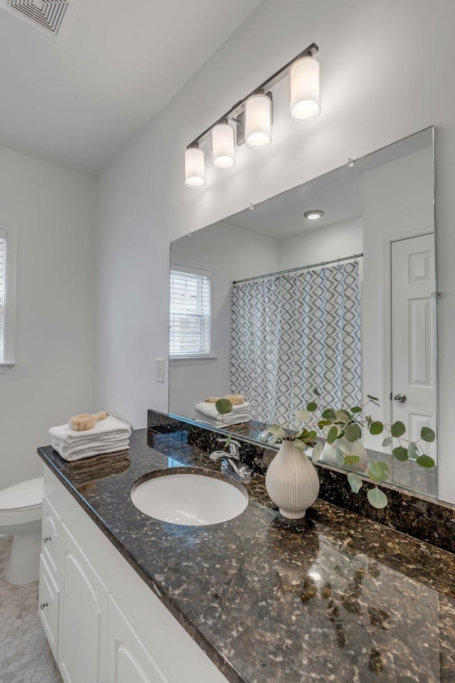 bathroom featuring vanity and toilet