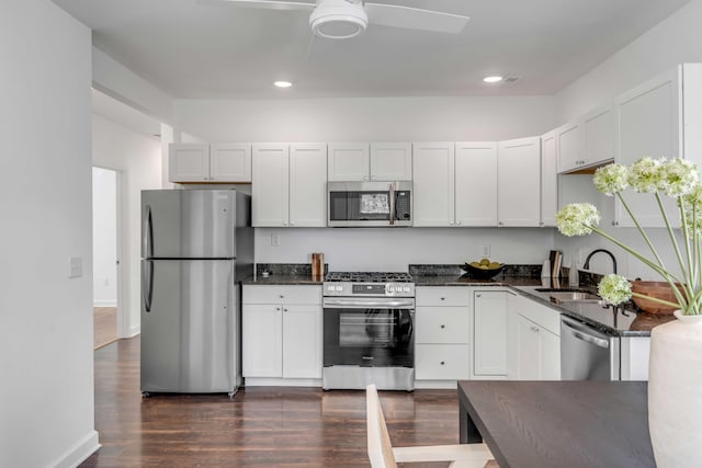 kitchen with sink, dark wood-type flooring, ceiling fan, stainless steel appliances, and white cabinets