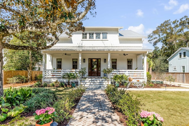 view of front of property featuring ceiling fan, a porch, a standing seam roof, and fence