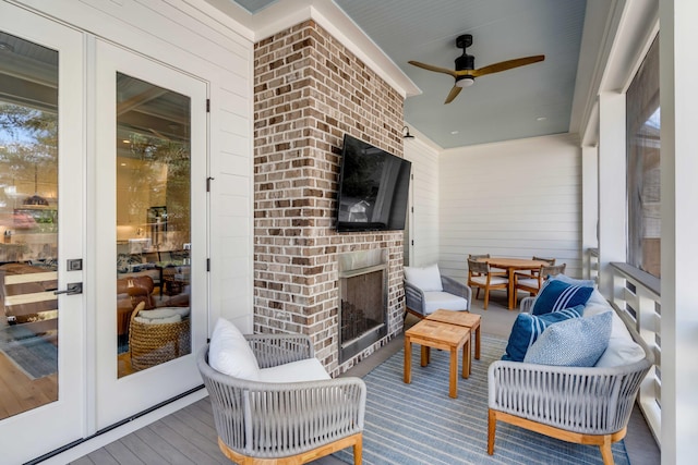 sunroom featuring an outdoor brick fireplace and a ceiling fan