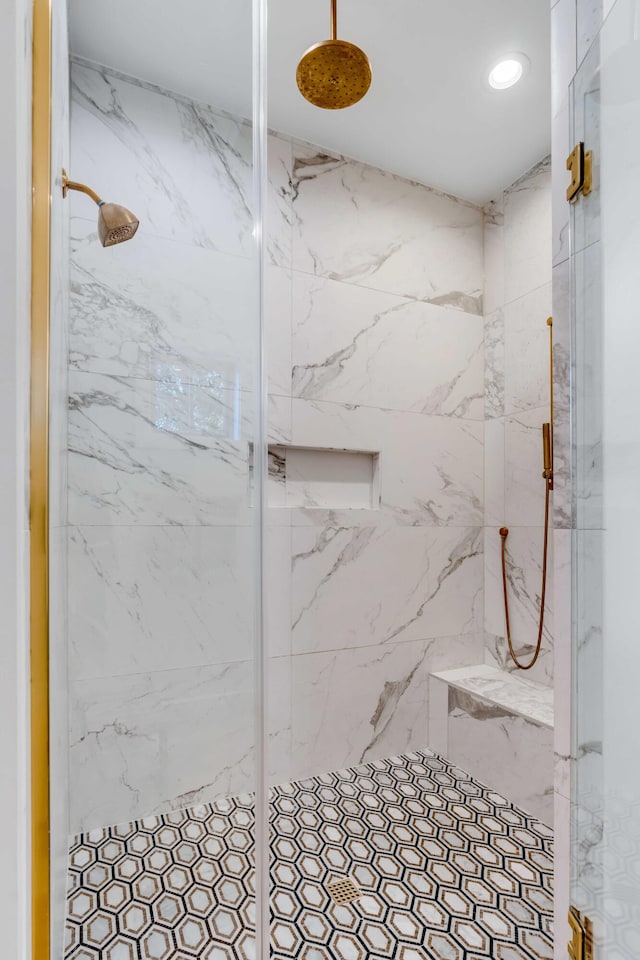 bathroom featuring a marble finish shower