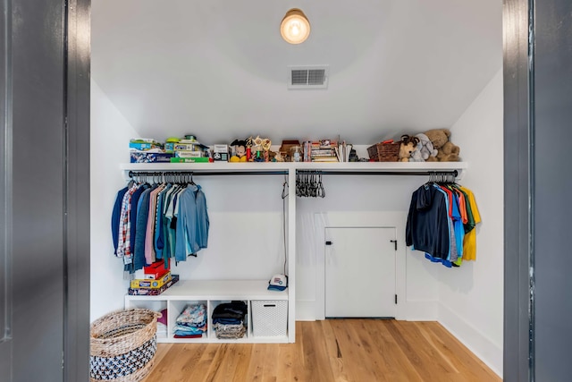 mudroom featuring lofted ceiling, visible vents, and wood finished floors