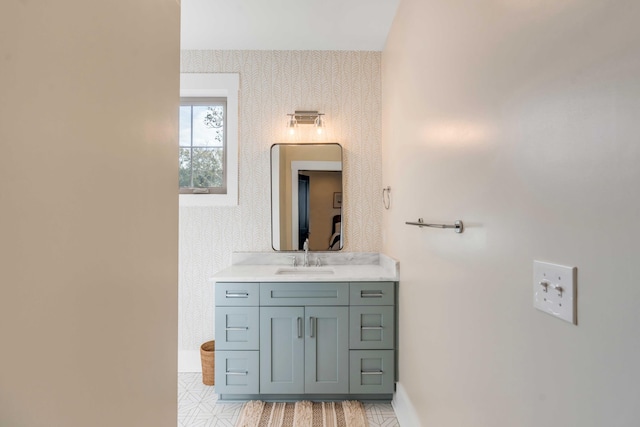 bathroom featuring visible vents, vanity, baseboards, and wallpapered walls