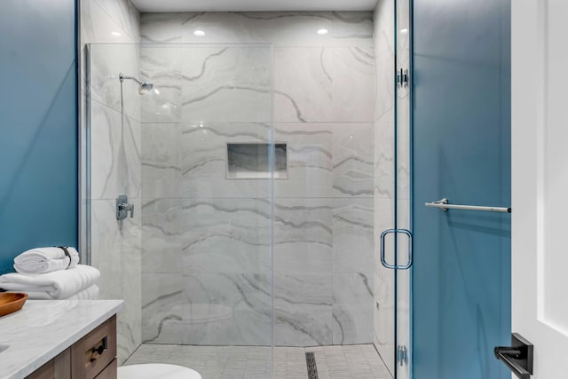 full bathroom featuring toilet, a marble finish shower, and vanity