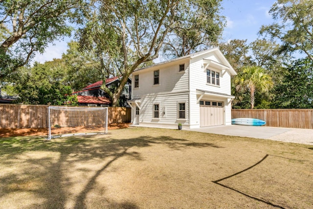 back of house featuring a garage, a patio area, fence, and concrete driveway