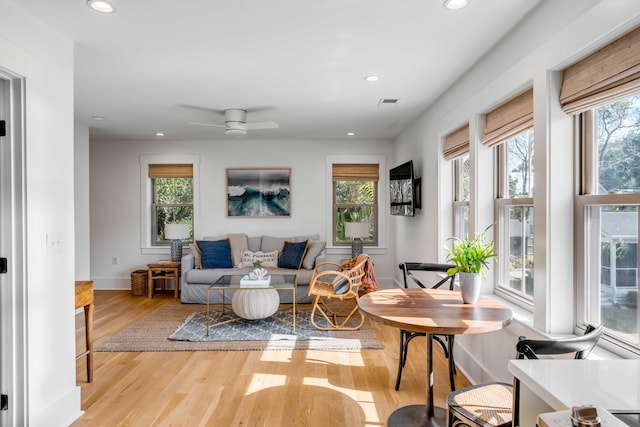 living area with recessed lighting, wood finished floors, and a healthy amount of sunlight