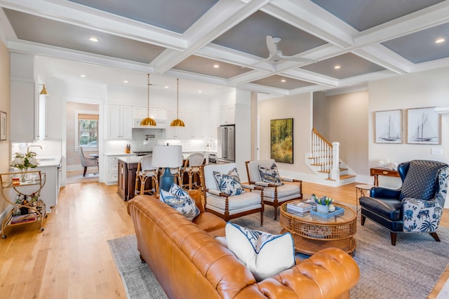 living room featuring beam ceiling, recessed lighting, light wood-style flooring, stairway, and coffered ceiling