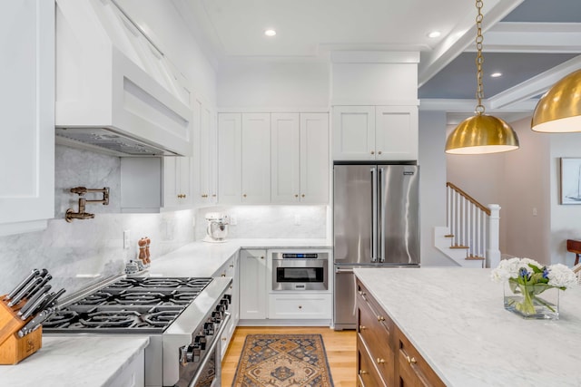 kitchen featuring light wood-style flooring, white cabinetry, high end appliances, and ventilation hood