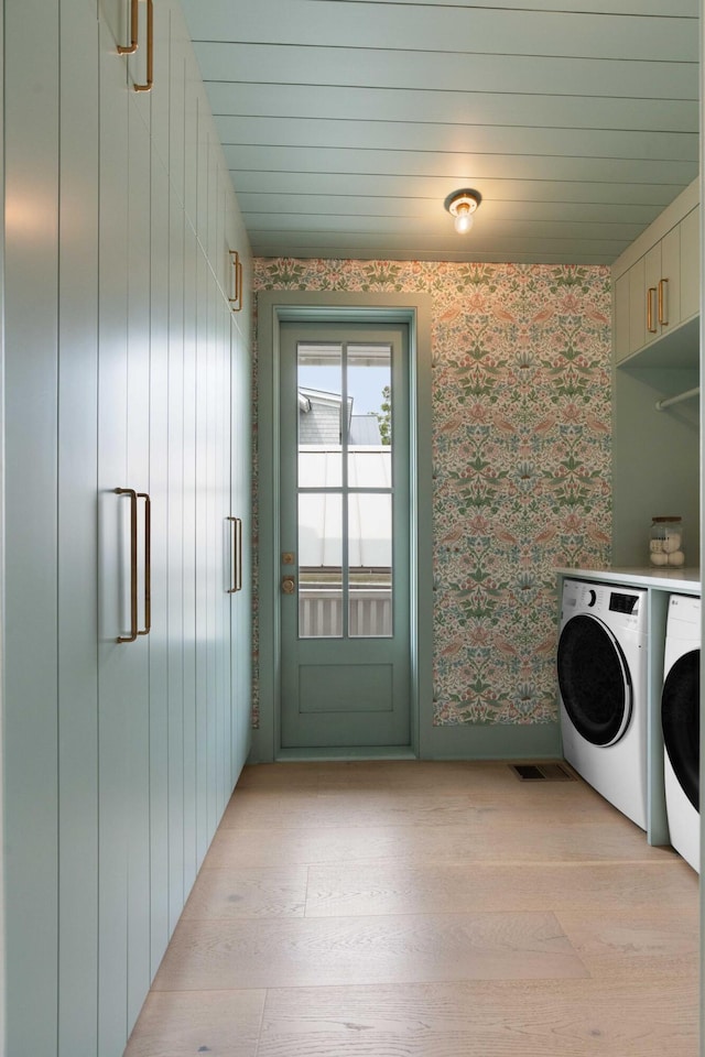 926 Pitt St, Mount Pleasant, SC 29464 - laundry room with washer and dryer, wallpapered walls, cabinet space, and light wood-style flooring