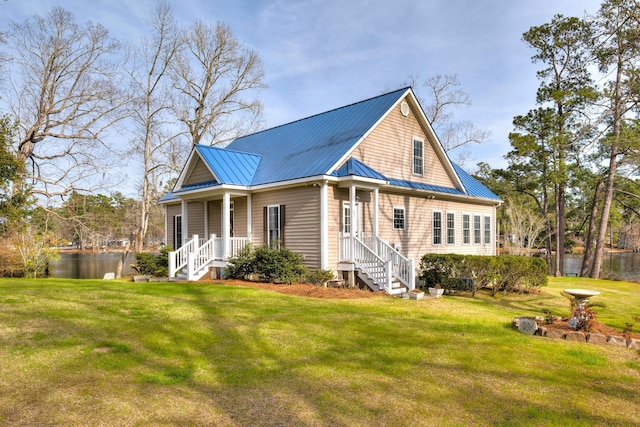 view of front of house with a standing seam roof, metal roof, and a front lawn