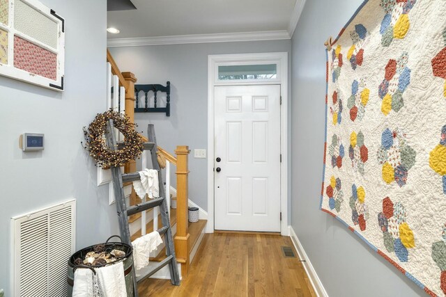 entryway featuring visible vents, stairway, light wood-type flooring, and ornamental molding