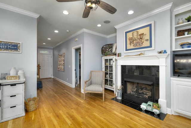 living area featuring a fireplace, recessed lighting, light wood-style floors, and ornamental molding