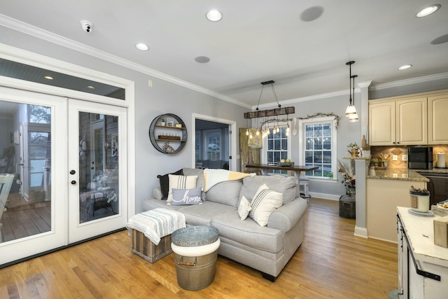 living room featuring baseboards, ornamental molding, recessed lighting, french doors, and light wood-style floors