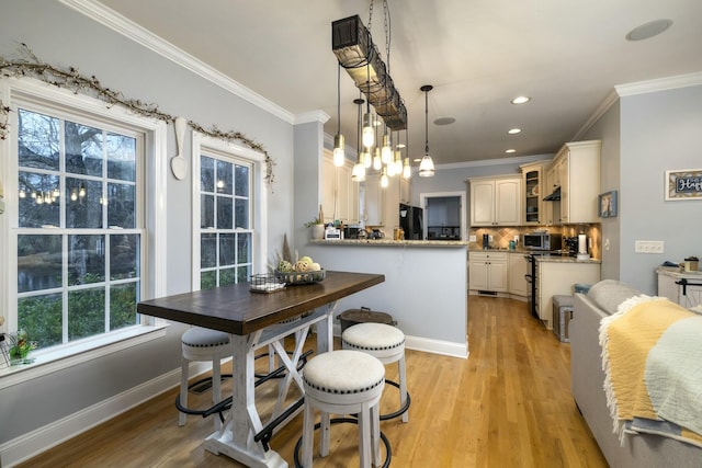 dining area with crown molding, recessed lighting, baseboards, and light wood finished floors