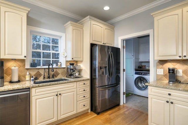 kitchen with washer / clothes dryer, cream cabinets, dishwasher, and black refrigerator with ice dispenser