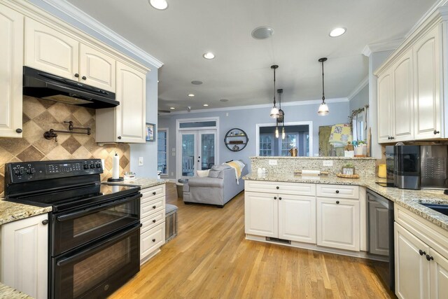 kitchen featuring a peninsula, range with two ovens, ornamental molding, under cabinet range hood, and light wood-type flooring