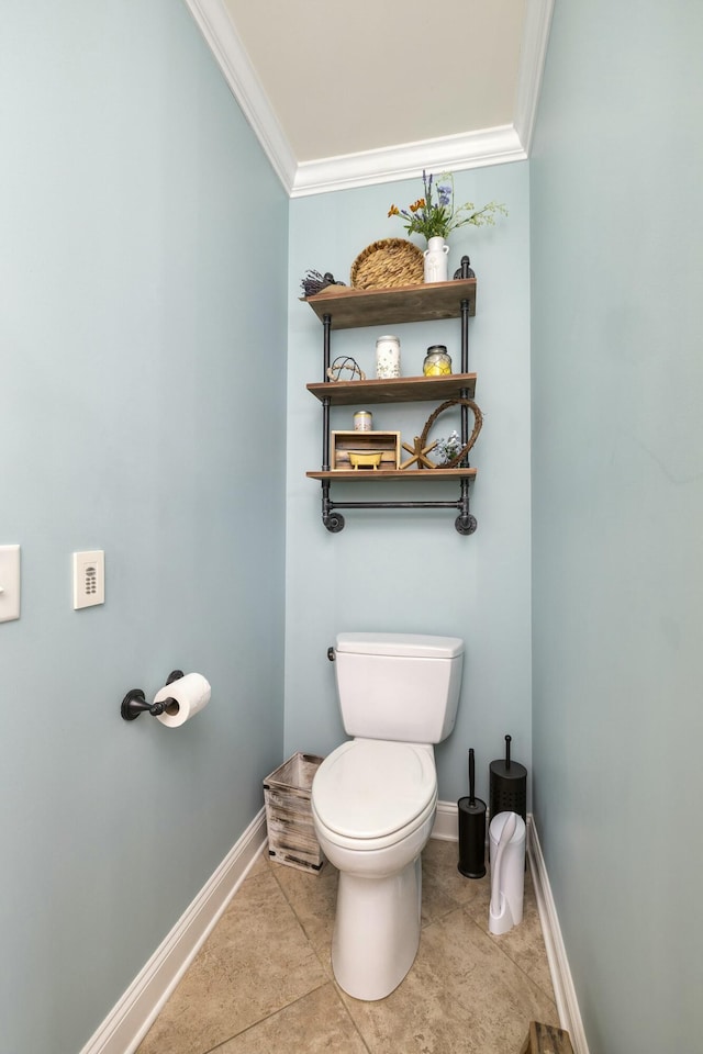 bathroom featuring baseboards, toilet, crown molding, and tile patterned flooring