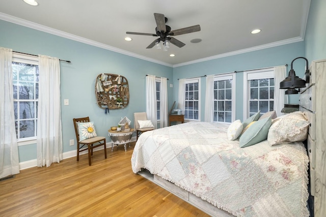 bedroom with baseboards, wood finished floors, and crown molding