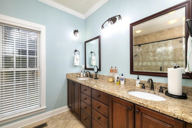 bathroom with tile patterned floors, ornamental molding, a shower stall, and a sink