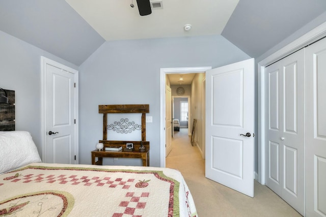 bedroom with light carpet, visible vents, a closet, and vaulted ceiling