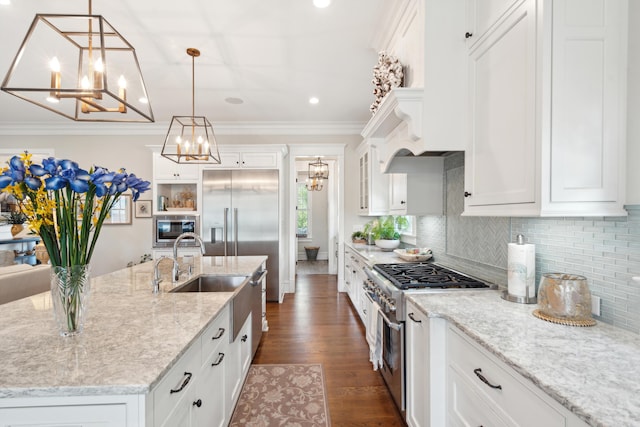 371 Bridgetown Pass, Mount Pleasant, SC 29464 - kitchen featuring built in appliances, a chandelier, white cabinetry, a center island with sink, and tasteful backsplash