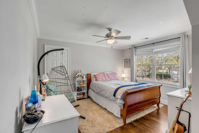 bedroom with visible vents, wood finished floors, a ceiling fan, and crown molding