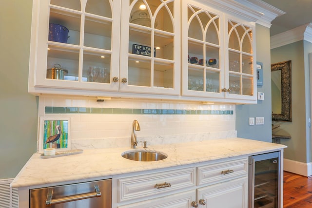 25 Ocean Point Dr, Isle Of Palms, SC 29451 - indoor wet bar featuring beverage cooler, ornamental molding, decorative backsplash, wood finished floors, and stainless steel dishwasher