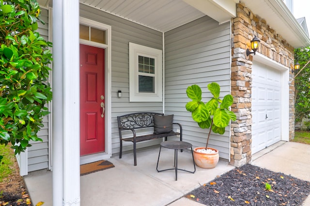 doorway to property featuring a garage and covered porch