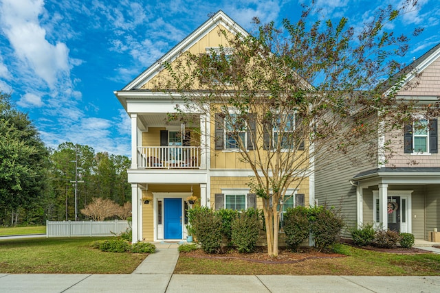 view of front of property with a balcony and a front lawn