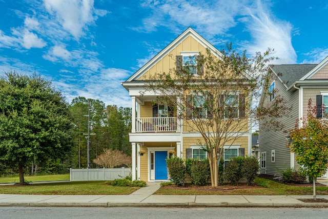 view of front of property featuring a balcony and a front lawn