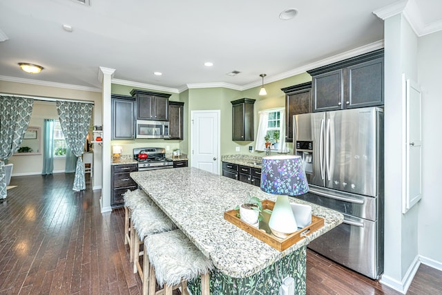 kitchen featuring dark hardwood / wood-style flooring, stainless steel appliances, a kitchen island, and dark brown cabinetry