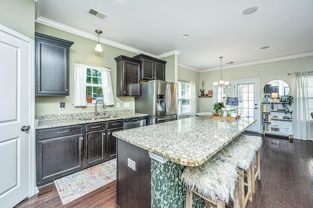 kitchen with dark hardwood / wood-style flooring, a center island, pendant lighting, and appliances with stainless steel finishes