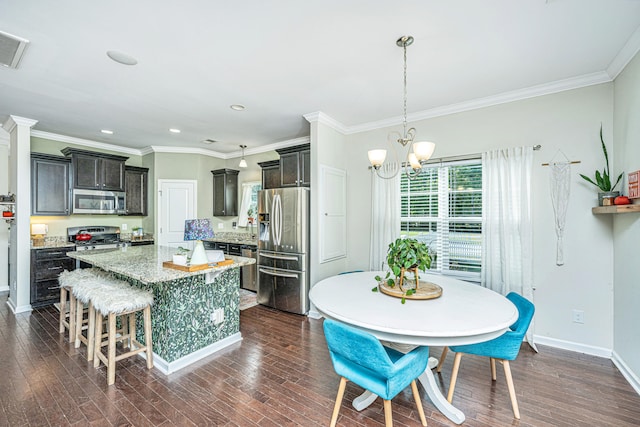 kitchen featuring appliances with stainless steel finishes, dark brown cabinets, dark wood-type flooring, an inviting chandelier, and a center island