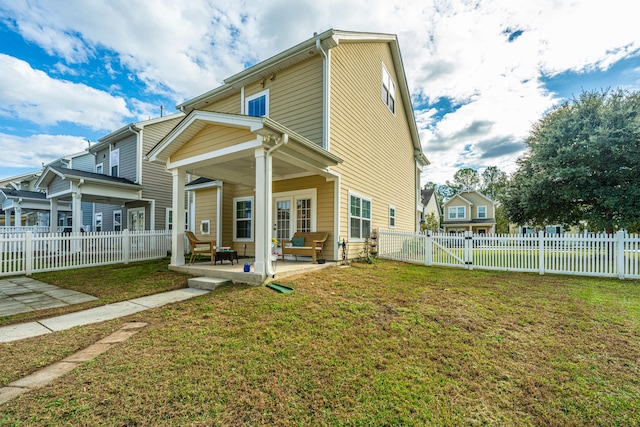 back of house with a yard and a patio