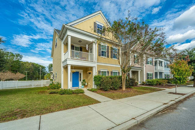 view of front of home with a balcony and a front lawn