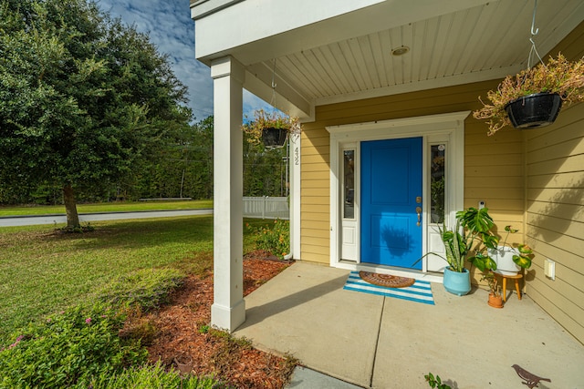 view of exterior entry with a yard