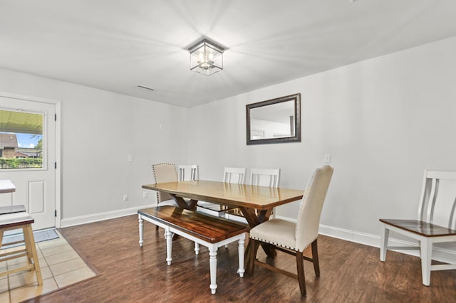dining space with wood finished floors, baseboards, and a chandelier